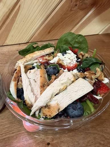 Fresh salad bowl with grilled chicken, berries, feta, walnuts, and spinach from J's On The Go
