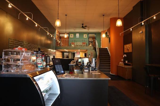 Warm café interior with counter, pastries, and pendant lighting